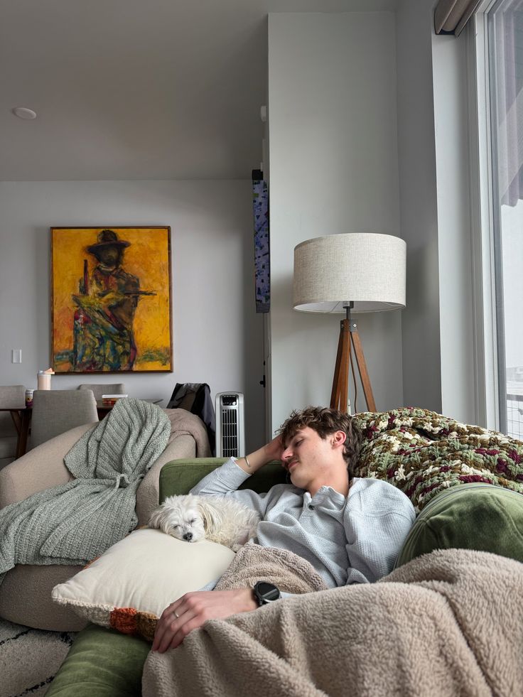 Hombre relajándose en casa junto a su perro mientras disfruta de una tarde de nesting y descanso en el sofá